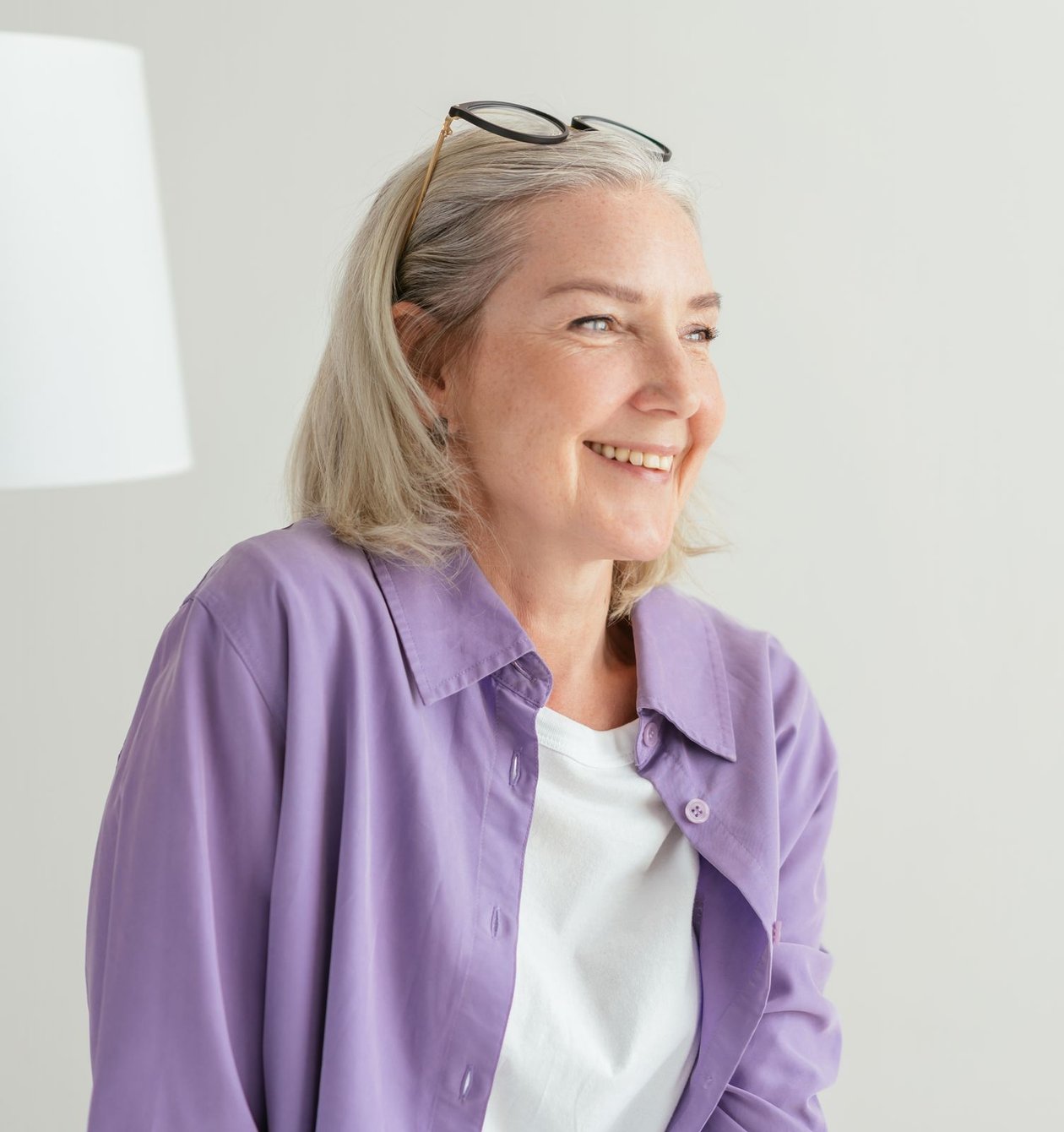 A woman in a lilac shirt smiling