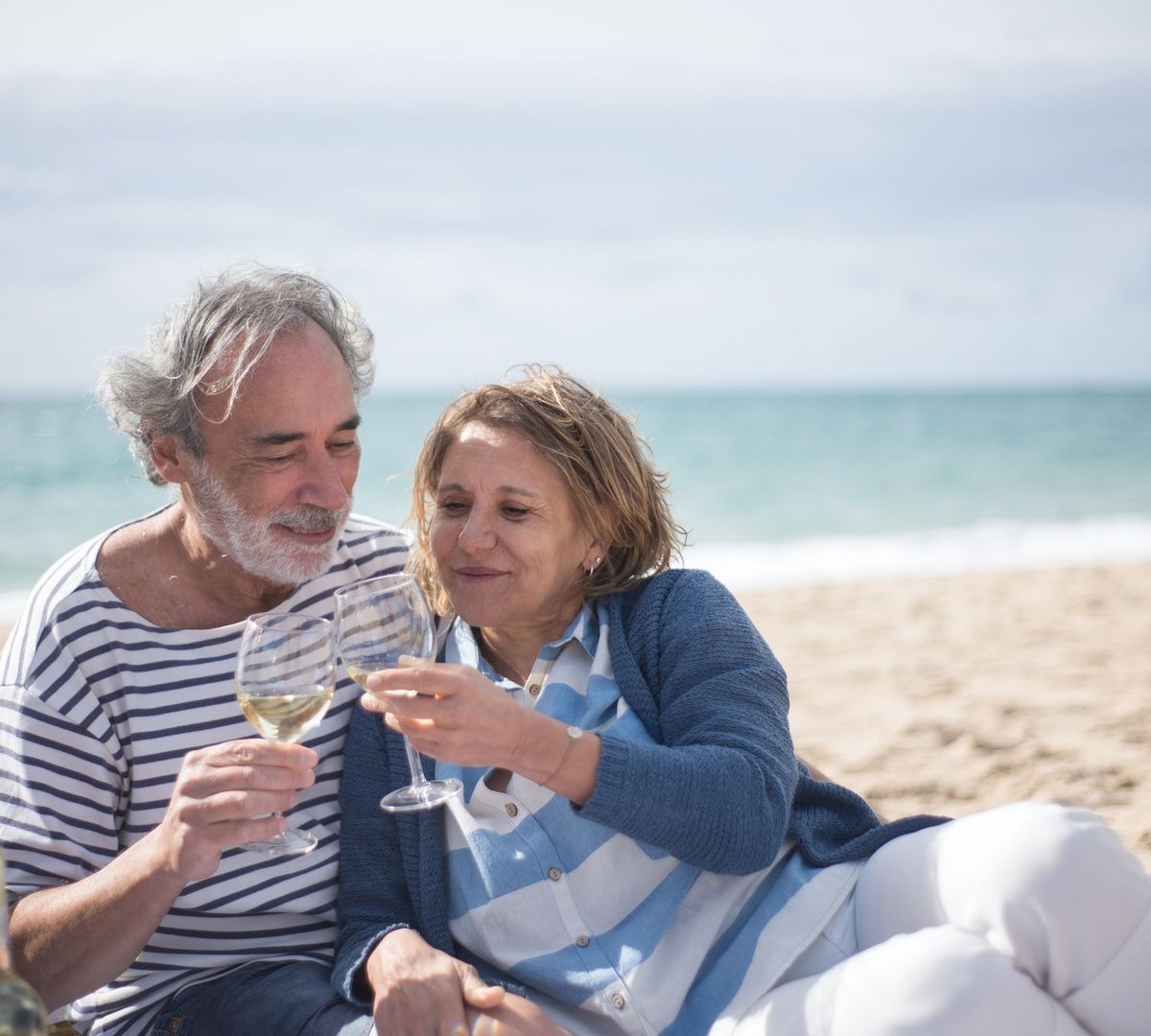 A couple sharing a glass of wine on the beach