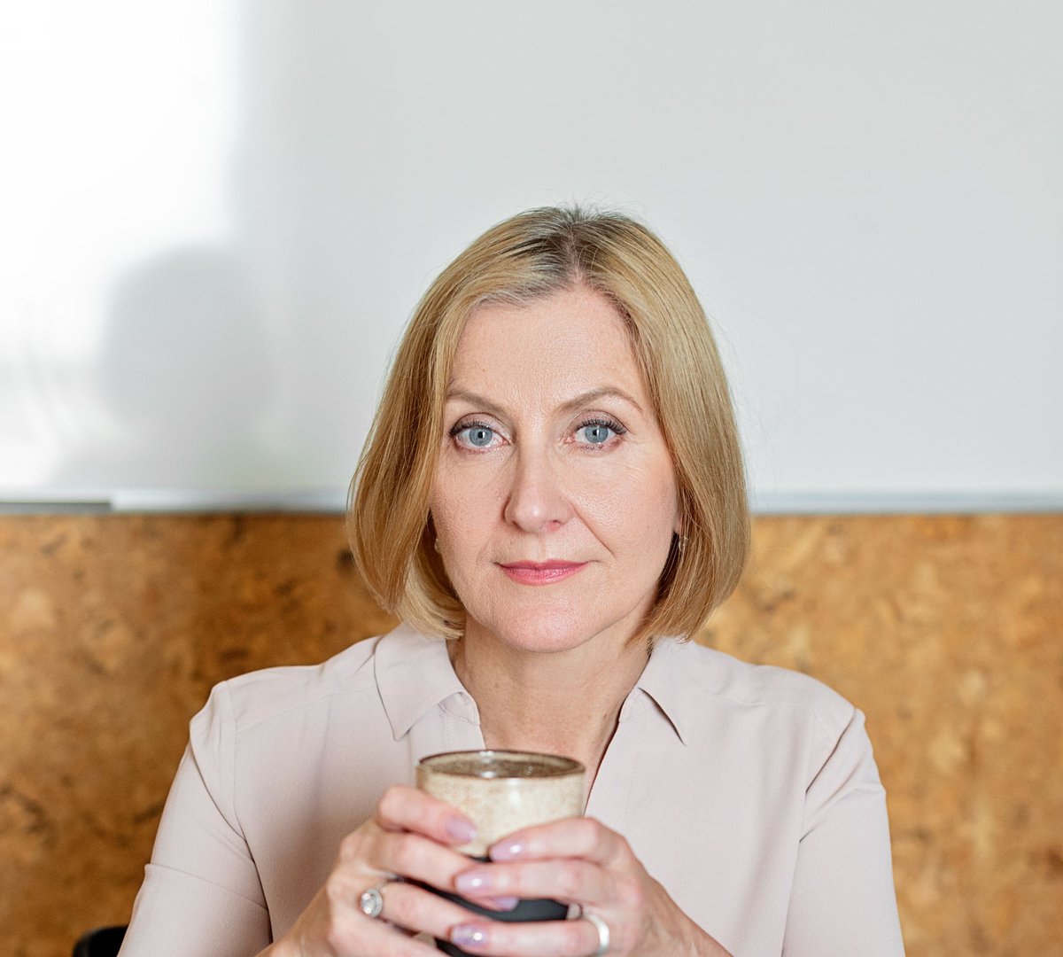 A woman with a cup of tea at her desk