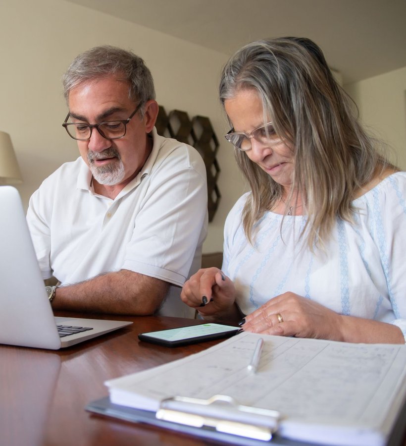A couple going over papers and a laptop at the table