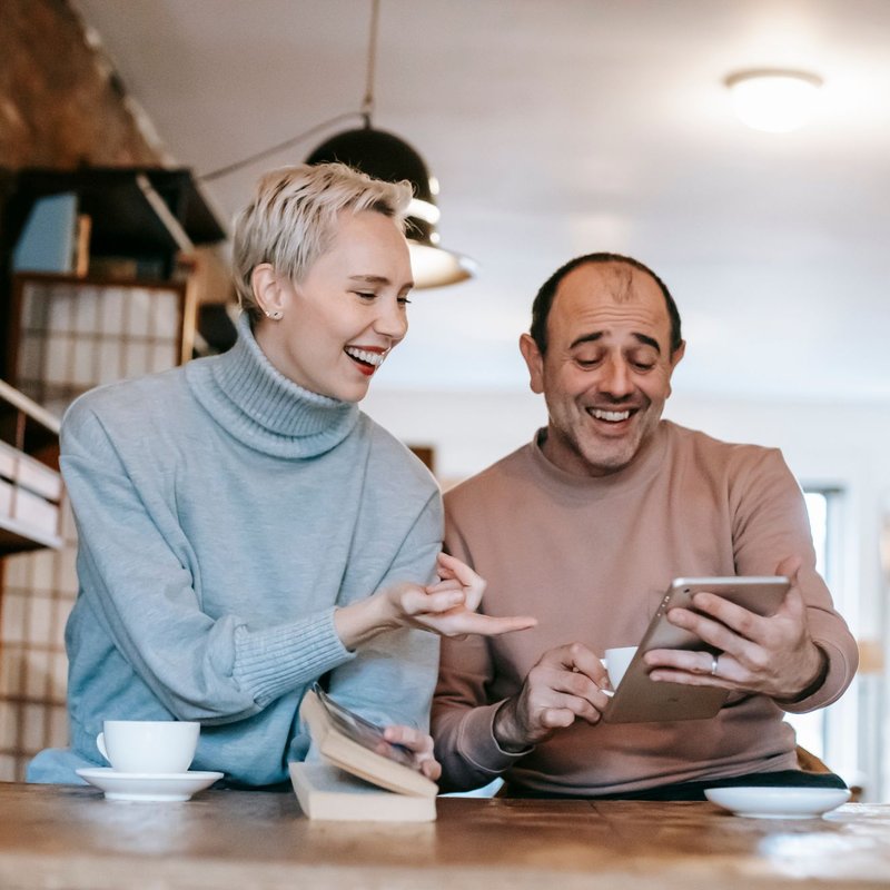 A couple laughing over a tablet